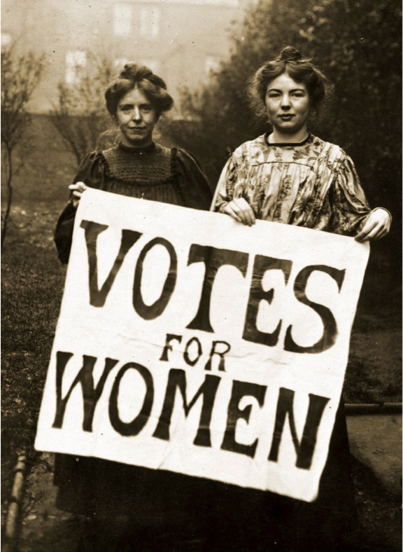 Two women holding a sign labeled 'Votes For Women'